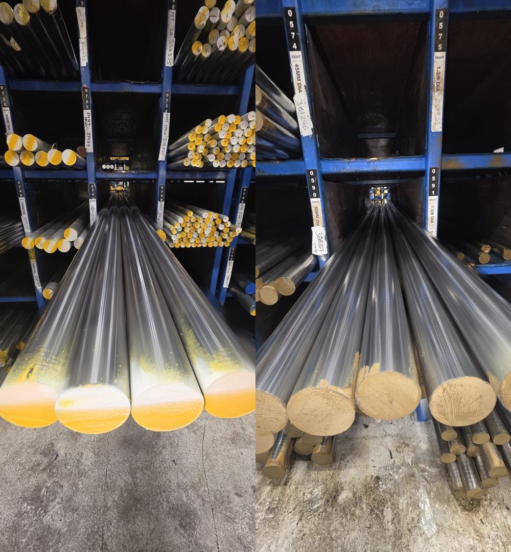 EN19T and EN24T bright round bar in pigeon-hole racking at Parkside Steel, photographed along the length of the bar so it converges into the rack. Rack labels read EN19T in 18mm, 55mm, 60mm and 75mm diameter on the left, and EN24T in 45mm, 60mm, 1.3/8 inch and 1.5/8 inch on the right.