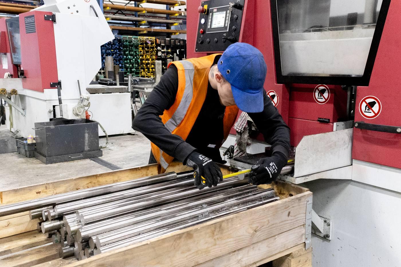 Operative at Behringer saw with multiple machines in background — full sawing capacity