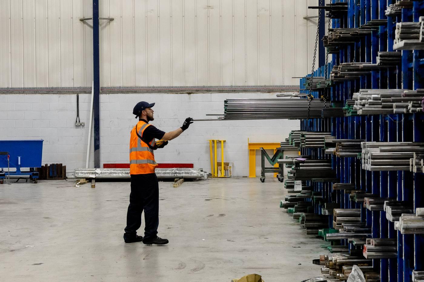 Operative picking bright round bar from blue cantilever racking — Parkside Steel stockholding facility