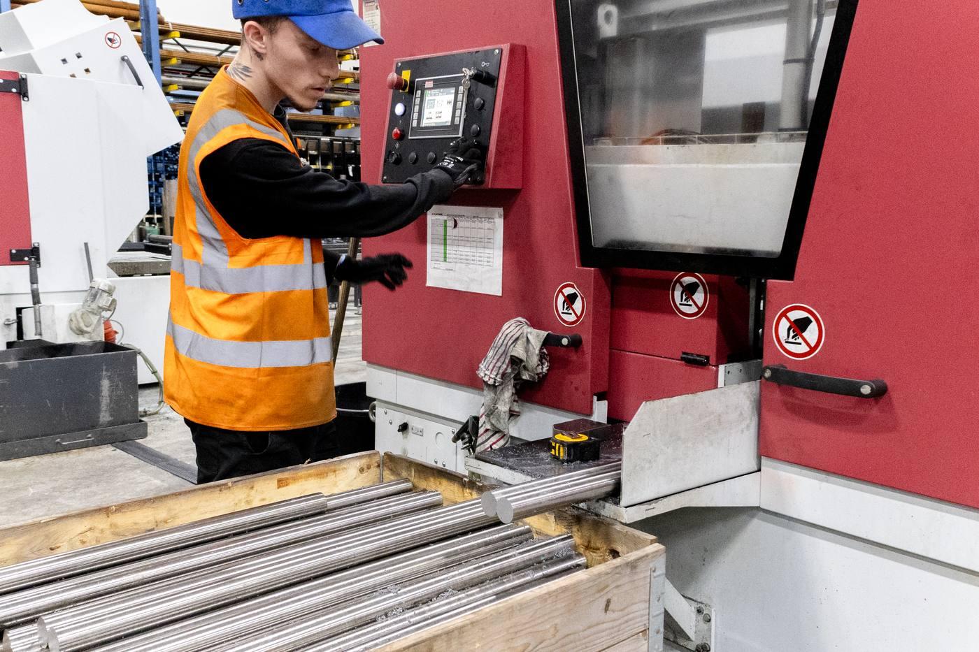Operative at Behringer band saw control panel with bright bar output in wooden stillage