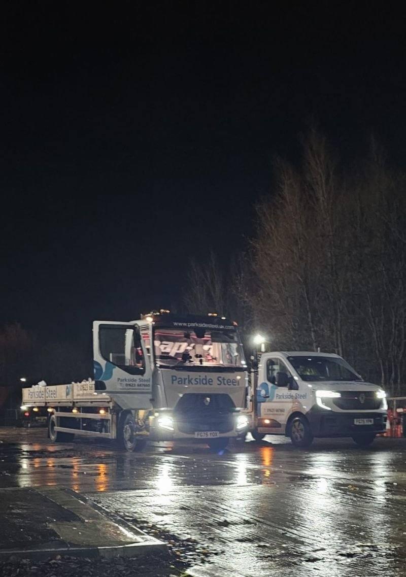 Parkside Steel branded flatbed truck and Renault Transit van departing — night departure showing 01623 687 660 branding