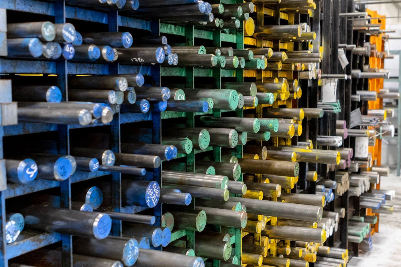Two operatives picking engineering steel bar from blue racking — Parkside Steel stockholding