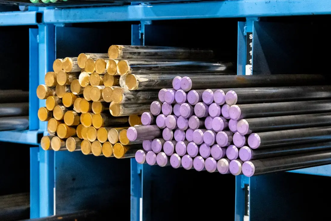 Bright bar ends in blue racking — yellow and purple colour-coded grade identification
